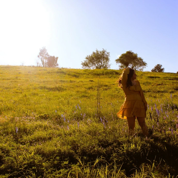 woman in yellow dress standing on green grass field during daytime